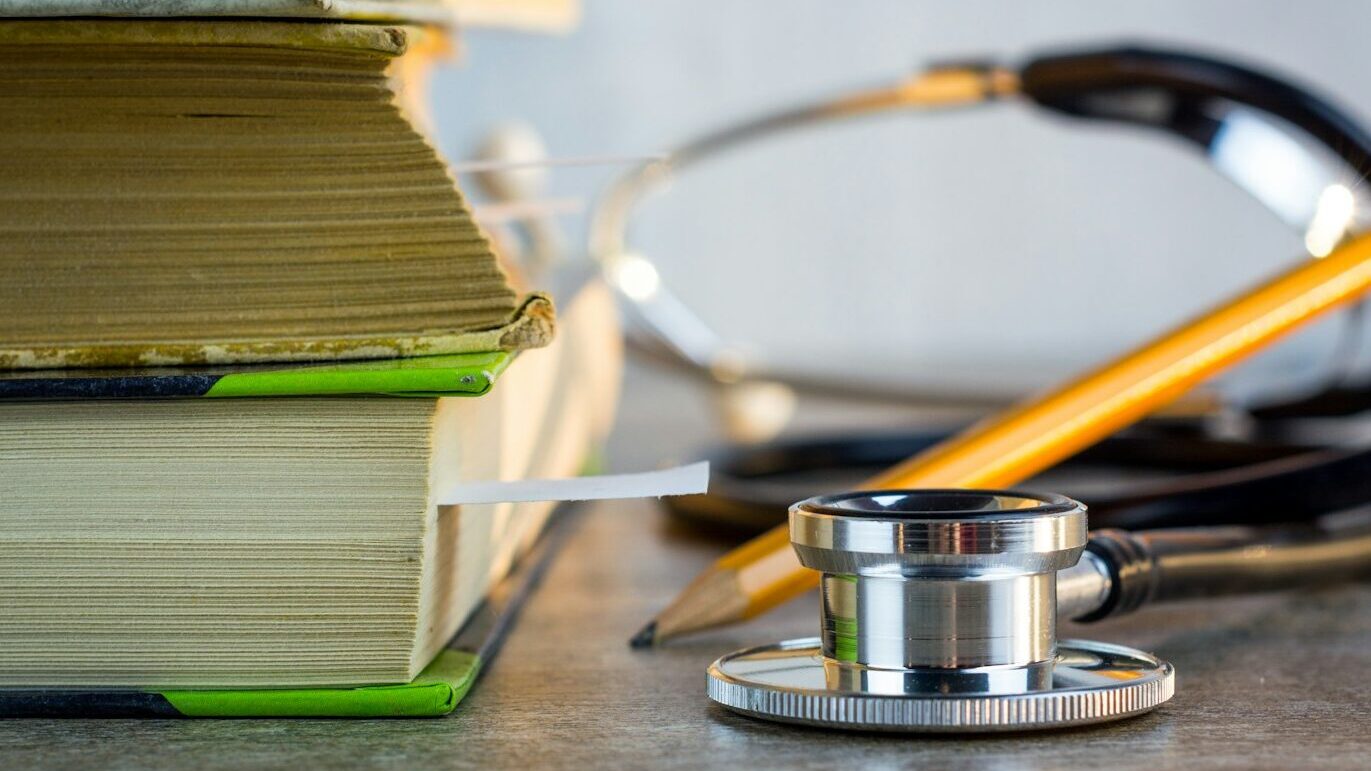 a stethoscope sitting on top of a pile of books