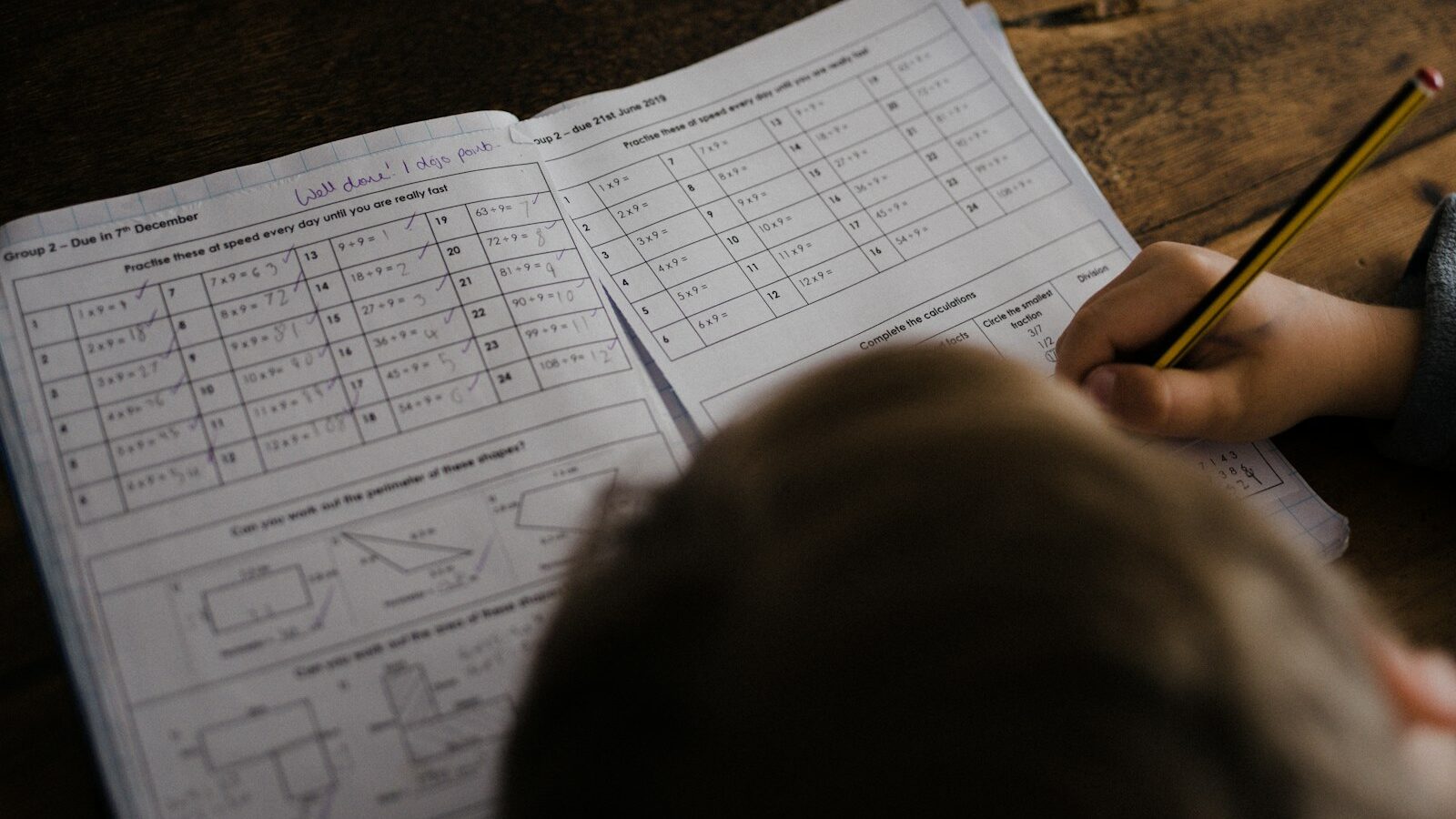 boy writes on his book on the desk